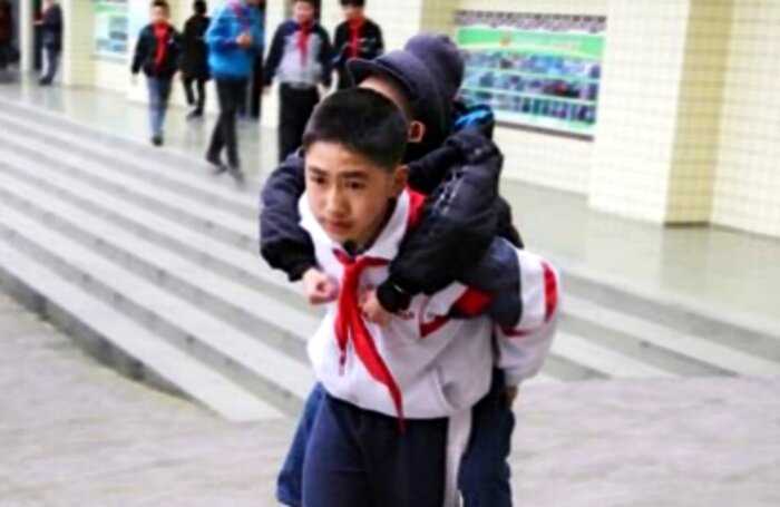 “Настоящий друг”: в Китае мальчик вот уже 6 лет носит в школу приятеля-инвалида