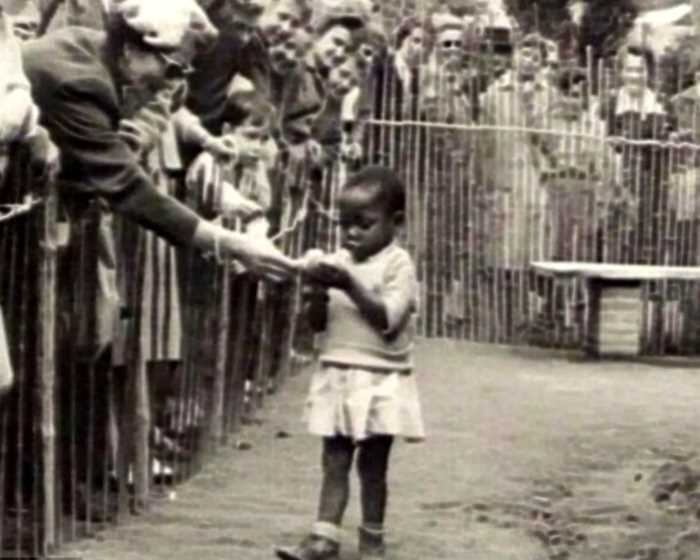 История знаменитого фото: Посетители кормят девочку-африканку в «человеческом зоопарке»